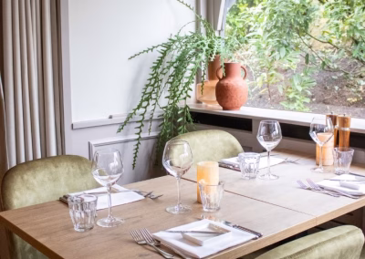 Interieur restaurant rust wat gedekte tafel plant in vensterbank
